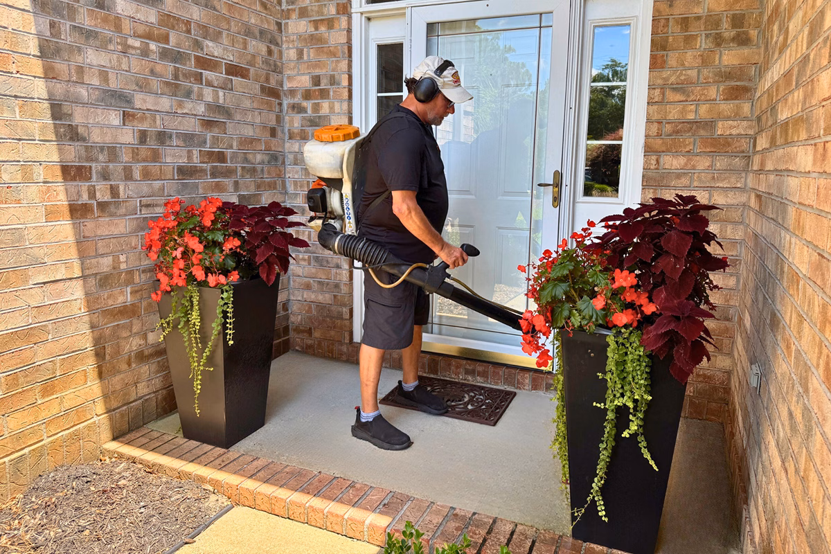 Exterminator sanitizing front of house